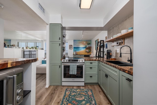 2800 N Atlantic Ave Unit 1409, Daytona Beach, FL 32118 - kitchen with green cabinetry, stainless steel electric range, and butcher block countertops