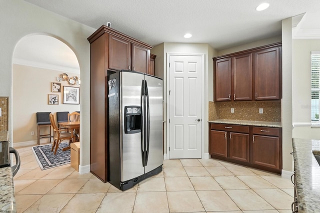 3842 Calliope Ave, Port Orange, FL 32129 - kitchen with stainless steel refrigerator with ice dispenser, arched walkways, crown molding, light tile patterned floors, and tasteful backsplash