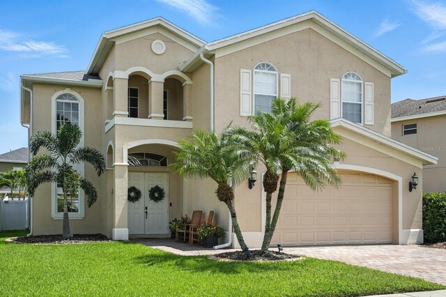3842 Calliope Ave, Port Orange, FL 32129 - view of front of property featuring stucco siding, a balcony, decorative driveway, a garage, and a front yard