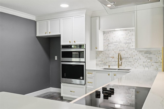 330 Ponce Deleon Blvd, De Leon Springs, FL 32130 - kitchen with double oven, decorative backsplash, white cabinetry, ornamental molding, and black electric stovetop
