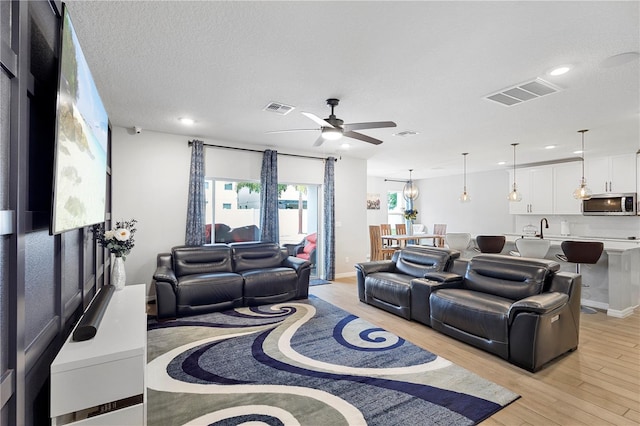 2807 Priego Blvd, Kissimmee, FL 34744 - living room with a ceiling fan, light wood-style floors, recessed lighting, and a textured ceiling
