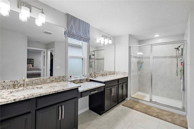 2807 Priego Blvd, Kissimmee, FL 34744 - bathroom with vanity, a stall shower, ensuite bathroom, tile patterned floors, and a textured ceiling