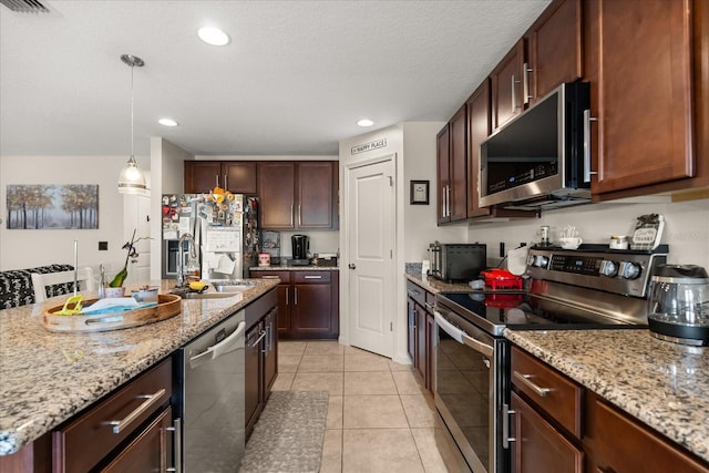 815 Fillmore Ct, Davenport, FL 33837 - kitchen featuring appliances with stainless steel finishes, pendant lighting, light tile patterned floors, light stone countertops, and recessed lighting