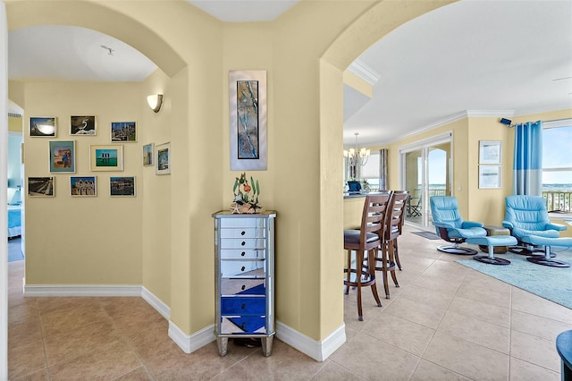 3343 S Atlantic Ave Unit 601, Daytona Beach Shores, FL 32118 - hallway with arched walkways, a chandelier, crown molding, and tile patterned flooring