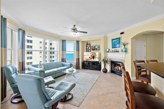 3343 S Atlantic Ave Unit 601, Daytona Beach Shores, FL 32118 - living room featuring arched walkways, a ceiling fan, a fireplace with flush hearth, healthy amount of natural light, and crown molding