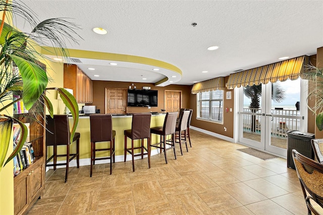 3343 S Atlantic Ave Unit 601, Daytona Beach Shores, FL 32118 - kitchen featuring dark countertops, a peninsula, a textured ceiling, a kitchen bar, and recessed lighting