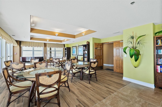 3343 S Atlantic Ave Unit 601, Daytona Beach Shores, FL 32118 - dining room featuring a raised ceiling, crown molding, and wood finished floors