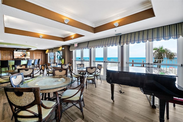 3343 S Atlantic Ave Unit 601, Daytona Beach Shores, FL 32118 - dining space with a tray ceiling, crown molding, a water view, wood finished floors, and recessed lighting