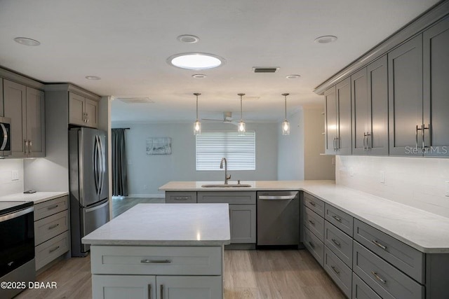 2017 Old Daytona Rd, Port Orange, FL 32128 - kitchen with appliances with stainless steel finishes, gray cabinets, a peninsula, light wood finished floors, and recessed lighting