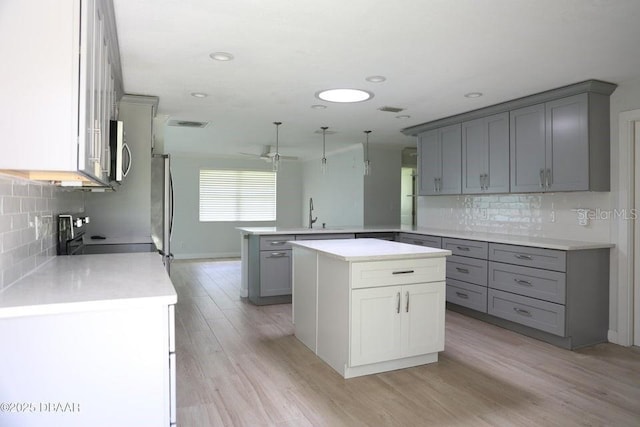 2017 Old Daytona Rd, Port Orange, FL 32128 - kitchen featuring a peninsula, stainless steel appliances, gray cabinetry, decorative backsplash, and recessed lighting
