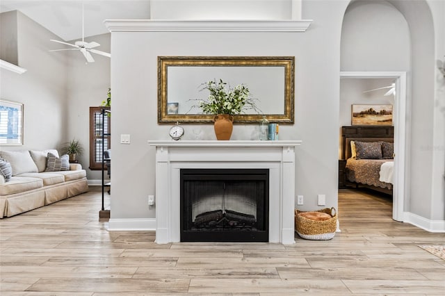 1636 Areca Palm Dr, Port Orange, FL 32128 - living area with ceiling fan, wood finished floors, a fireplace, arched walkways, and a towering ceiling