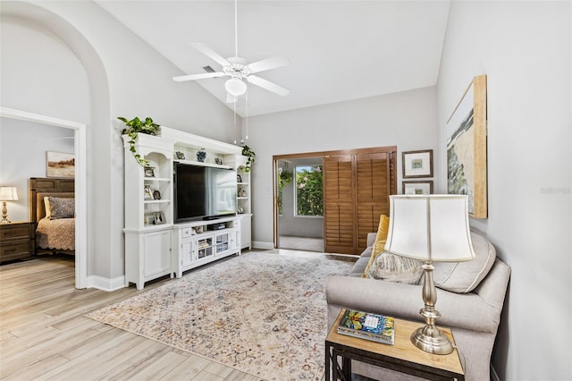 1636 Areca Palm Dr, Port Orange, FL 32128 - living room featuring a ceiling fan, light wood-style flooring, arched walkways, and high vaulted ceiling