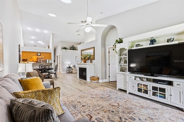 1636 Areca Palm Dr, Port Orange, FL 32128 - living room with a ceiling fan, a glass covered fireplace, light wood-type flooring, high vaulted ceiling, and recessed lighting
