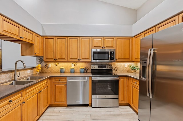 1636 Areca Palm Dr, Port Orange, FL 32128 - kitchen featuring appliances with stainless steel finishes, backsplash, brown cabinetry, light wood-style flooring, and dark countertops