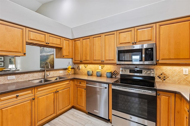 1636 Areca Palm Dr, Port Orange, FL 32128 - kitchen featuring appliances with stainless steel finishes, brown cabinetry, backsplash, light wood-type flooring, and vaulted ceiling