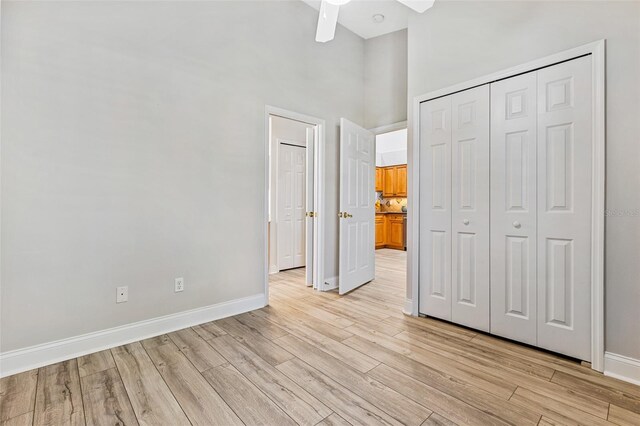 1636 Areca Palm Dr, Port Orange, FL 32128 - unfurnished bedroom with a towering ceiling, light wood-style floors, a closet, and a ceiling fan