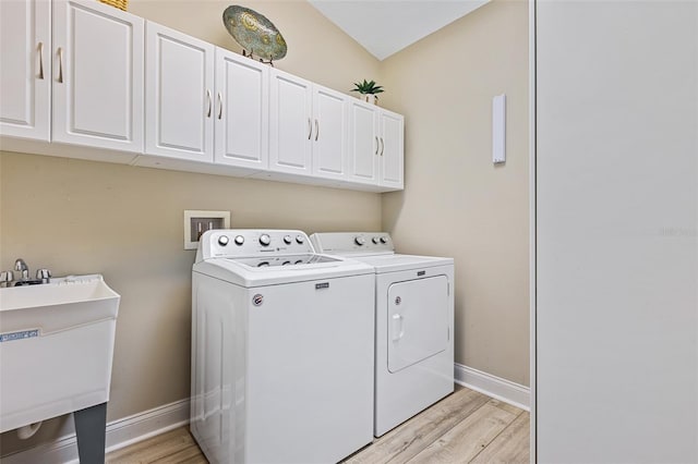 1636 Areca Palm Dr, Port Orange, FL 32128 - laundry area featuring washing machine and clothes dryer, light wood-style flooring, and cabinet space