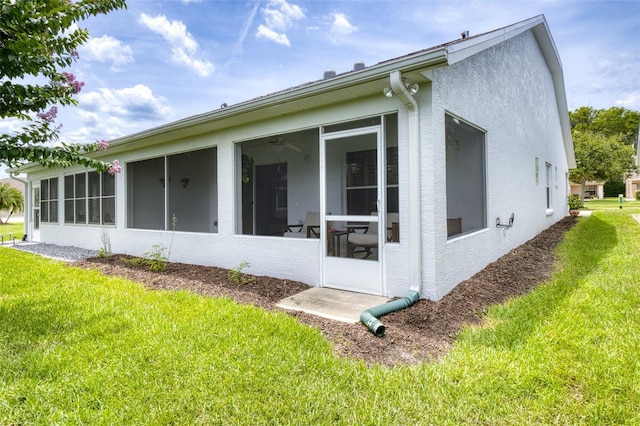 1636 Areca Palm Dr, Port Orange, FL 32128 - back of property featuring a sunroom, a lawn, and stucco siding