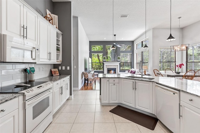 6710 Merryvale Ln, Port Orange, FL 32128 - kitchen with white appliances, a glass covered fireplace, open shelves, a ceiling fan, and decorative backsplash