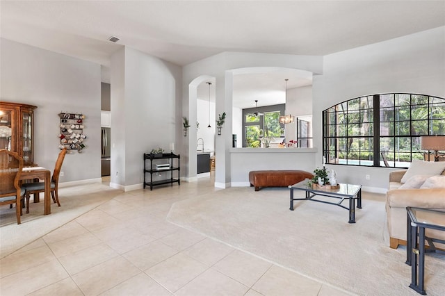 6710 Merryvale Ln, Port Orange, FL 32128 - living area with light tile patterned floors, arched walkways, and light colored carpet