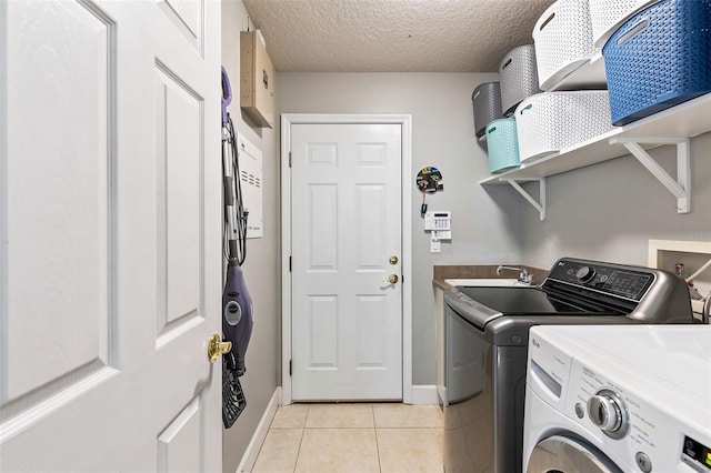 6710 Merryvale Ln, Port Orange, FL 32128 - laundry area with washer and clothes dryer, light tile patterned flooring, and a textured ceiling
