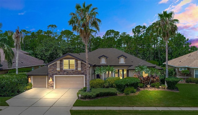 6710 Merryvale Ln, Port Orange, FL 32128 - view of front of house featuring concrete driveway, stone siding, a lawn, and a garage