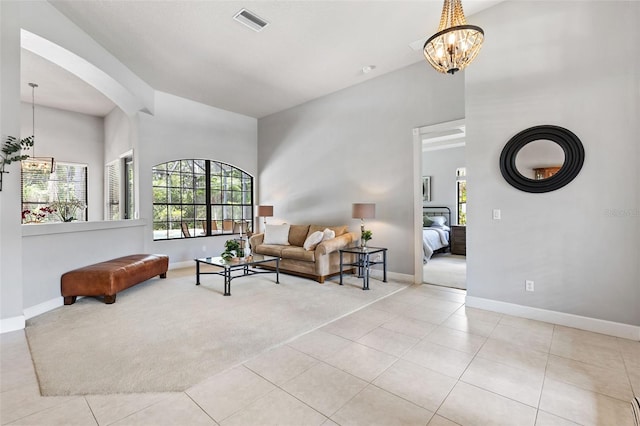 6710 Merryvale Ln, Port Orange, FL 32128 - living area with a chandelier, light colored carpet, a towering ceiling, arched walkways, and light tile patterned flooring