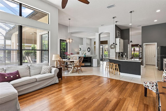 6710 Merryvale Ln, Port Orange, FL 32128 - living room featuring ceiling fan, light wood-style floors, arched walkways, a chandelier, and recessed lighting