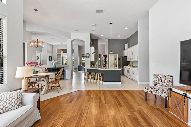 6710 Merryvale Ln, Port Orange, FL 32128 - living area with arched walkways, a chandelier, light wood-style floors, and recessed lighting