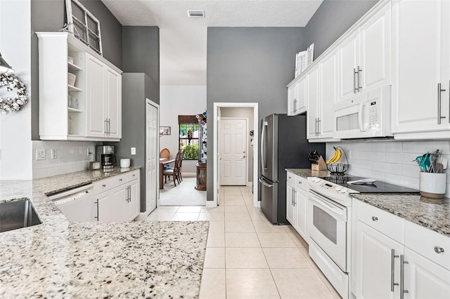 6710 Merryvale Ln, Port Orange, FL 32128 - kitchen featuring white appliances, open shelves, white cabinetry, and a textured ceiling