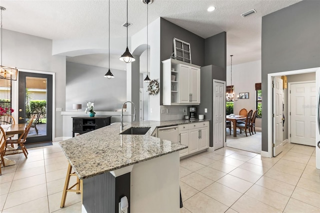 6710 Merryvale Ln, Port Orange, FL 32128 - kitchen featuring open shelves, a peninsula, white cabinetry, a chandelier, and light stone counters