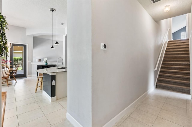 6710 Merryvale Ln, Port Orange, FL 32128 - staircase with a textured ceiling and tile patterned flooring