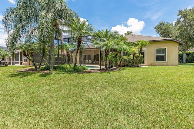 6710 Merryvale Ln, Port Orange, FL 32128 - back of house featuring stucco siding, a lawn, and glass enclosure