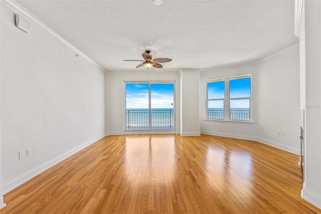 2515 S Atlantic Ave Unit 507, Daytona Beach, FL 32118 - empty room featuring a textured ceiling, healthy amount of natural light, ceiling fan, light wood-style flooring, and ornamental molding