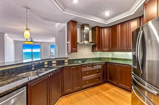2515 S Atlantic Ave Unit 507, Daytona Beach, FL 32118 - kitchen with stainless steel appliances, wall chimney exhaust hood, light wood-style floors, dark stone countertops, and hanging light fixtures