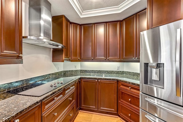 2515 S Atlantic Ave Unit 507, Daytona Beach, FL 32118 - kitchen featuring stainless steel fridge, wall chimney range hood, black electric stovetop, dark stone countertops, and light wood finished floors