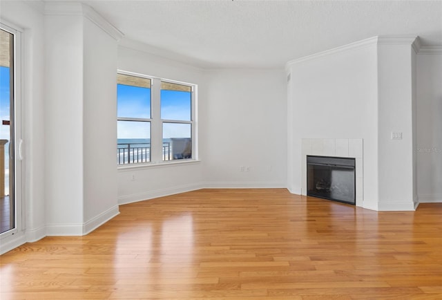 2515 S Atlantic Ave Unit 507, Daytona Beach, FL 32118 - unfurnished living room with a tile fireplace, light wood-style floors, and crown molding