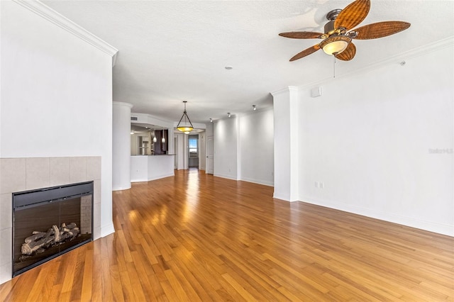 2515 S Atlantic Ave Unit 507, Daytona Beach, FL 32118 - unfurnished living room with a ceiling fan, light wood finished floors, a tiled fireplace, and crown molding