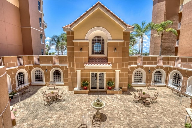 2515 S Atlantic Ave Unit 507, Daytona Beach, FL 32118 - rear view of house with french doors, stucco siding, a tiled roof, and a patio