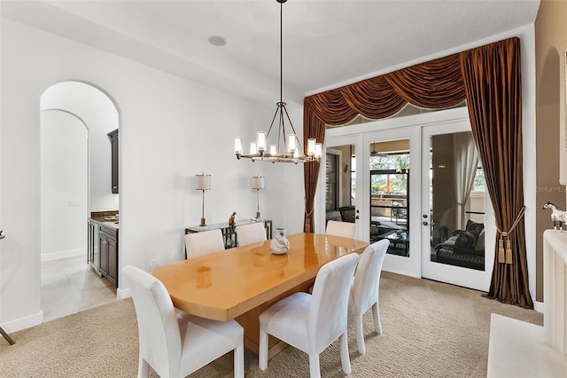 12812 Jacob Grace Ct, Windermere, FL 34786 - dining room featuring light colored carpet, arched walkways, a chandelier, and french doors