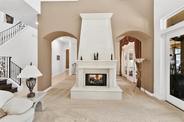 12812 Jacob Grace Ct, Windermere, FL 34786 - living room with light colored carpet, a high ceiling, stairs, and arched walkways
