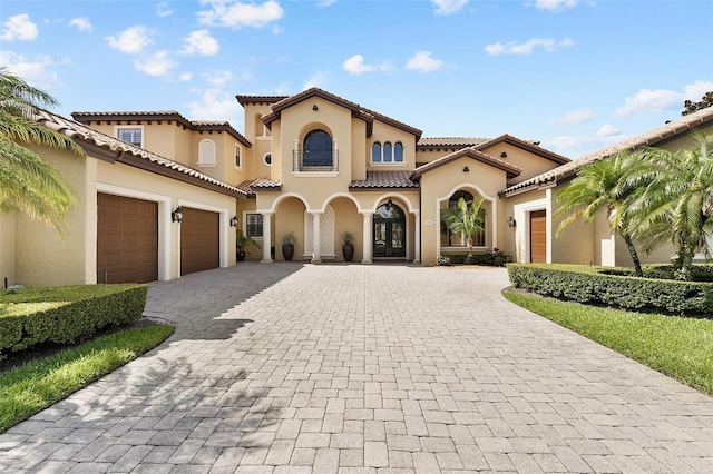 12812 Jacob Grace Ct, Windermere, FL 34786 - mediterranean / spanish home featuring a garage, decorative driveway, stucco siding, and a tiled roof