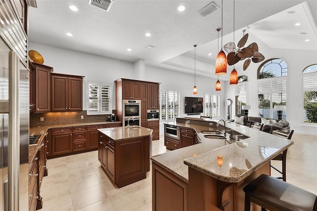 12812 Jacob Grace Ct, Windermere, FL 34786 - kitchen featuring a spacious island, backsplash, stainless steel double oven, recessed lighting, and a kitchen breakfast bar