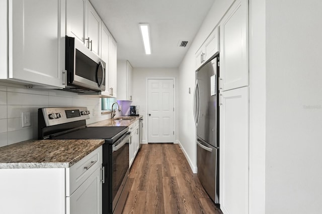 2931 Lantern Dr, South Daytona, FL 32119 - kitchen featuring appliances with stainless steel finishes, dark wood-style floors, decorative backsplash, and white cabinetry