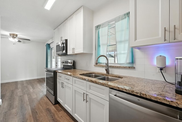 2931 Lantern Dr, South Daytona, FL 32119 - kitchen with appliances with stainless steel finishes, a ceiling fan, white cabinets, light stone countertops, and wood finished floors