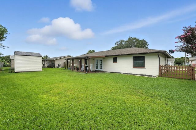 2931 Lantern Dr, South Daytona, FL 32119 - back of property with french doors, a fenced backyard, a shed, and roof with shingles