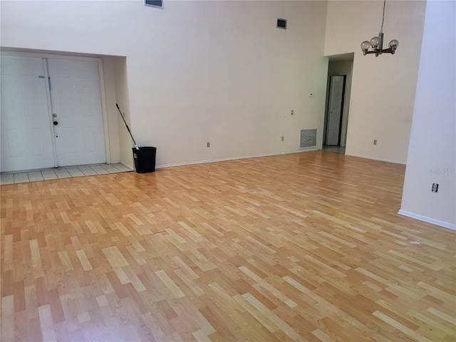 5915 Crystal View Dr, Orlando, FL 32819 - spare room with light wood-type flooring, a towering ceiling, and a chandelier