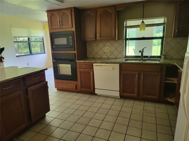 5915 Crystal View Dr, Orlando, FL 32819 - kitchen featuring black appliances, tasteful backsplash, plenty of natural light, and stone counters