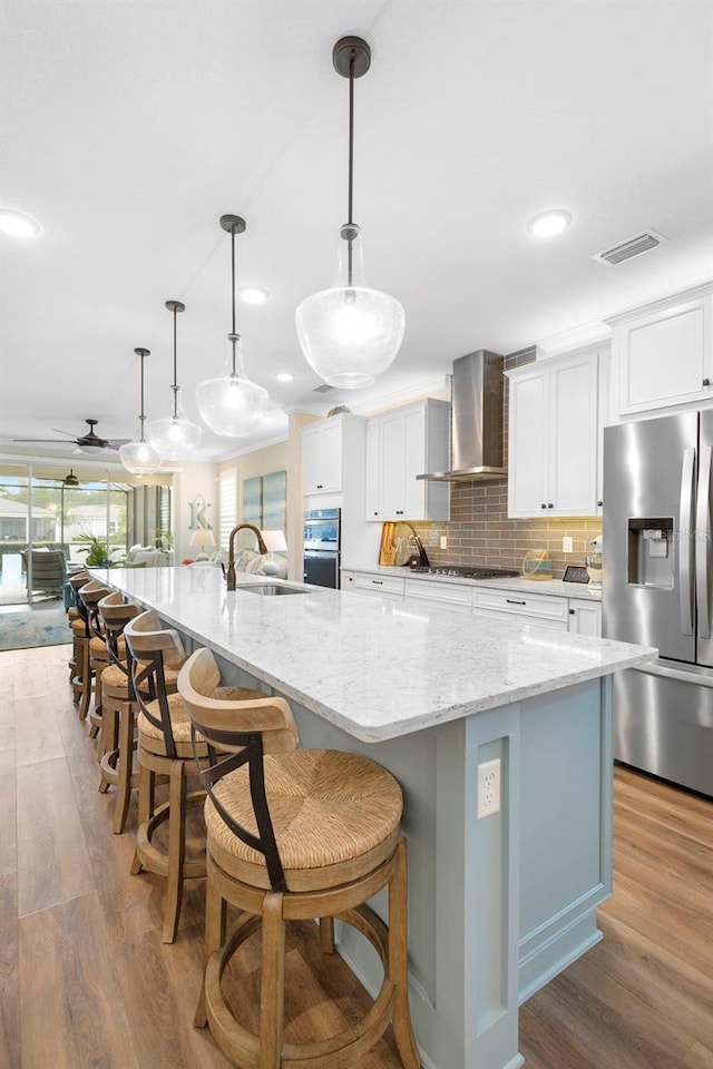 249 Kellet Way, Saint Johns, FL 32259 - kitchen with stainless steel fridge, light wood-style floors, a large island with sink, white cabinets, and recessed lighting