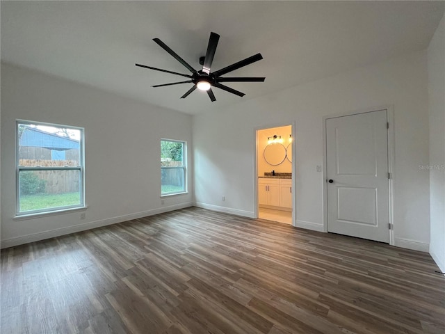 1510 Granada Ave, Daytona Beach, FL 32117 - unfurnished bedroom with dark wood finished floors, connected bathroom, and a ceiling fan